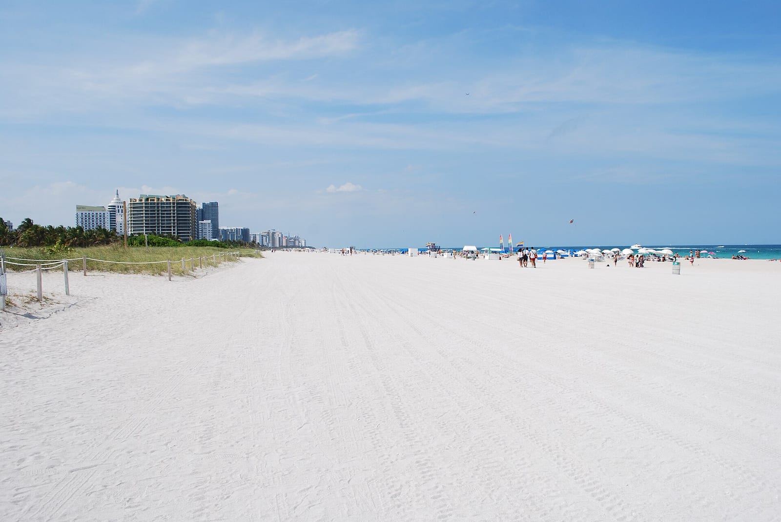 Miami Beach: wide sandy beach with distant beachgoers, hotels, and turquoise ocean