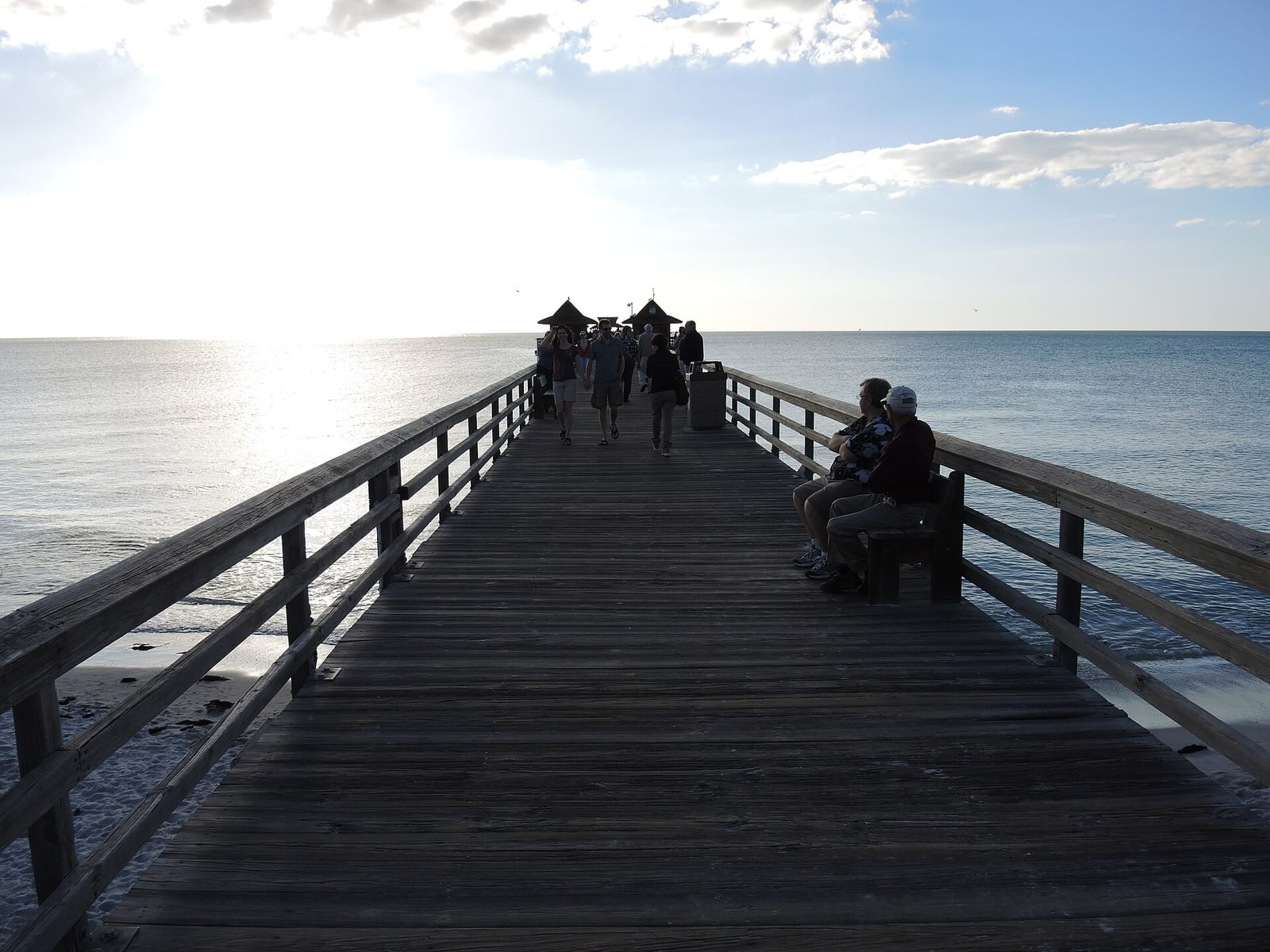 5th Avenue South Beach: wooden pier extending into calm ocean with distant figures and pavilion