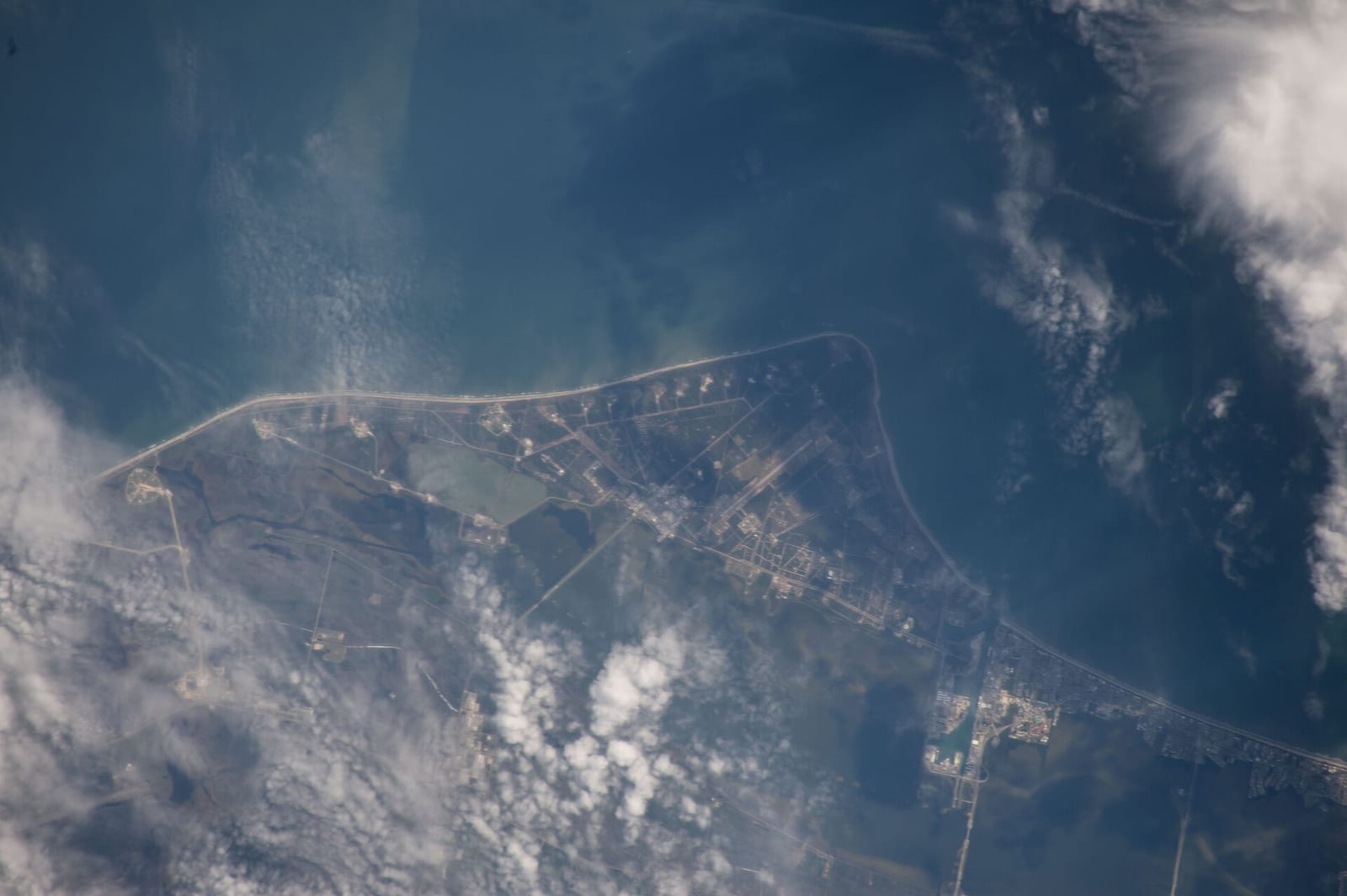 Apollo Beach: aerial view of curved coastal peninsula with developed shoreline and water