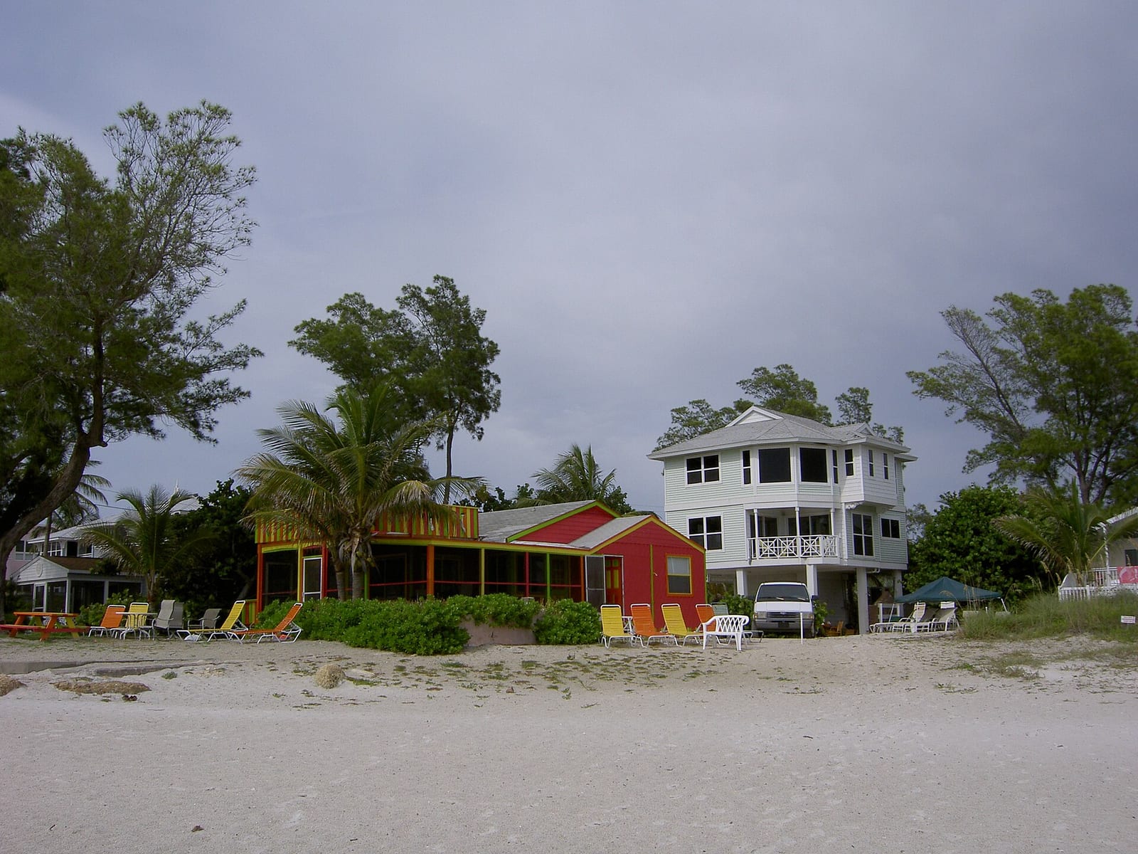 Bradenton Beach: beachfront houses and structures on sand with palm trees