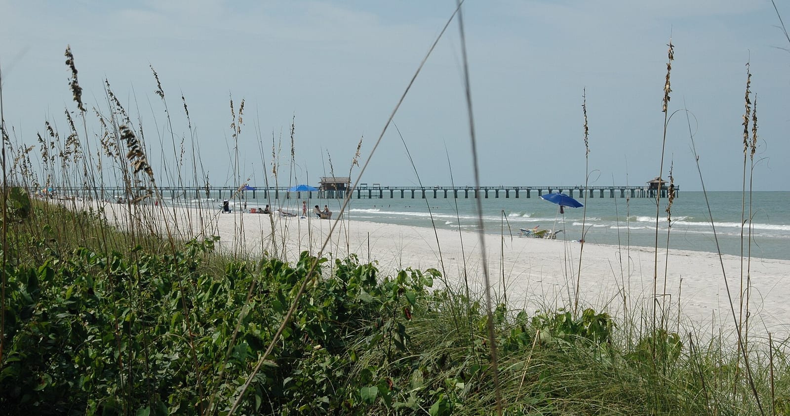 Central Avenue Beach: beach with dune vegetation, pier, sailboat, and calm ocean water