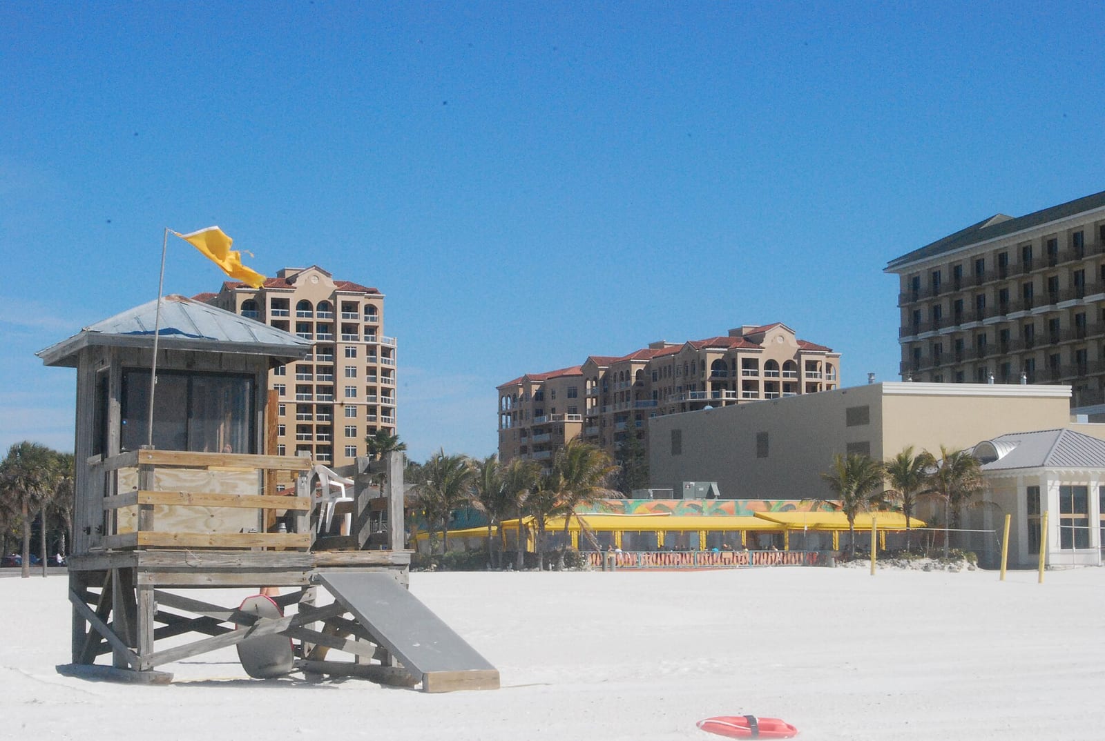 Clearwater Beach: lifeguard tower on sandy beach with coastal buildings and palm trees