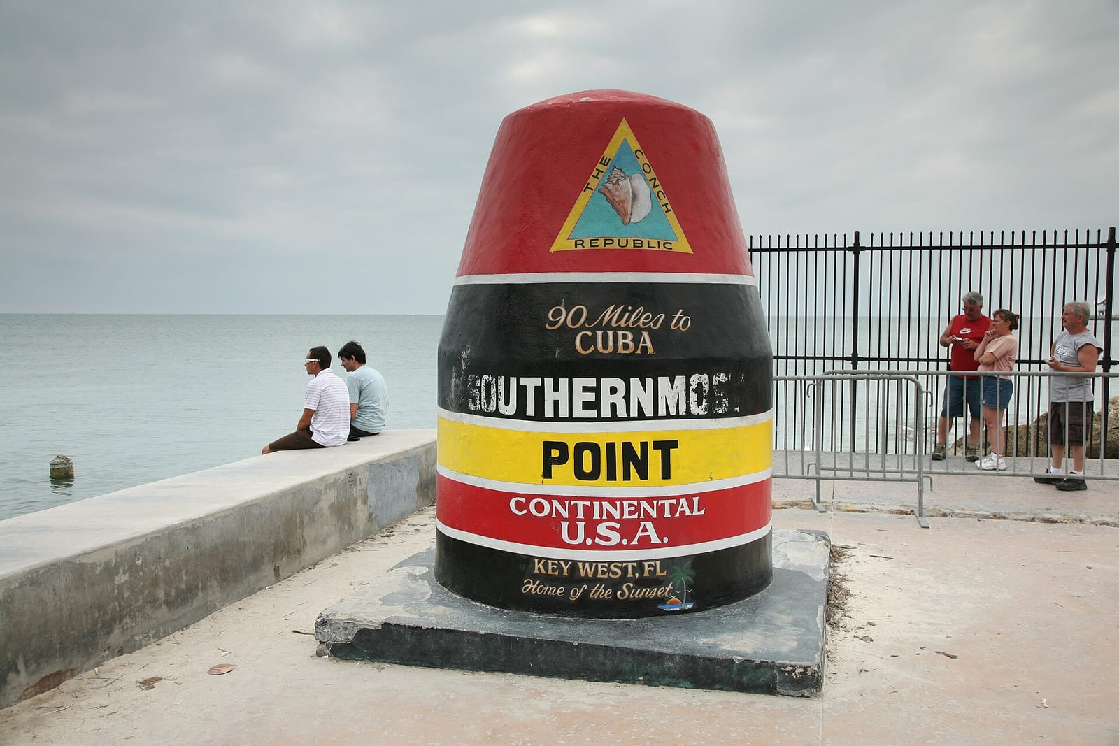 Dog Beach: southernmost Point marker at Key West beach with visitors and ocean