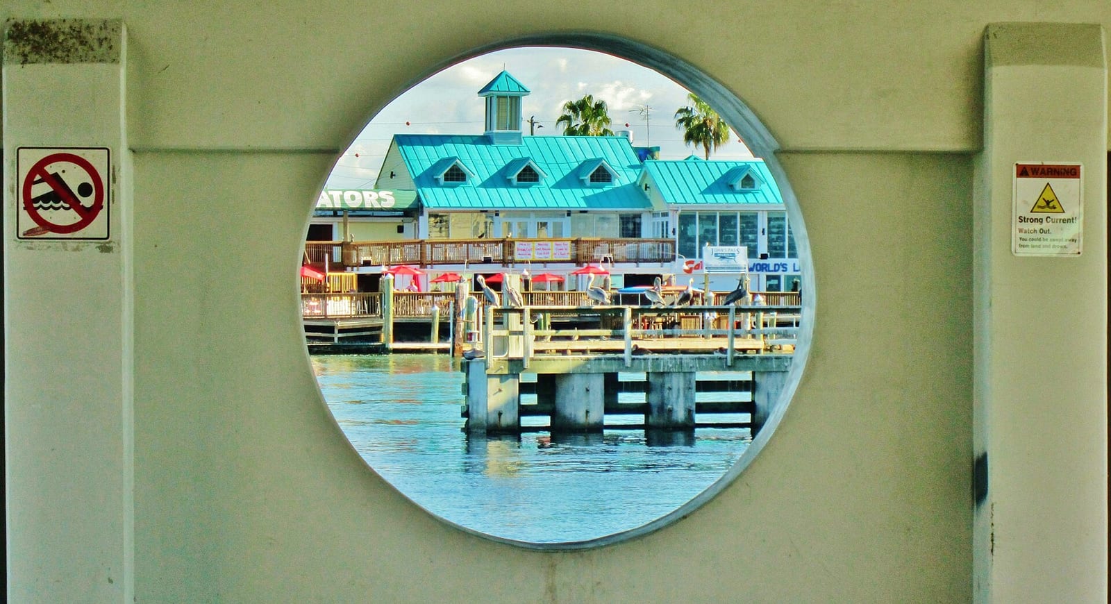 Hubbard's Beach: waterfront building with turquoise roof viewed through circular window
