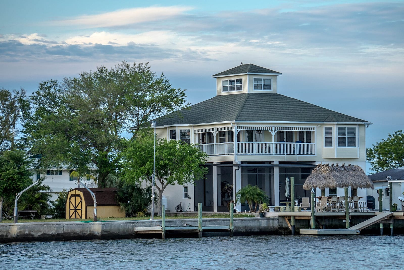 Hudson Beach: waterfront house on stilts with dock and thatched roof structure