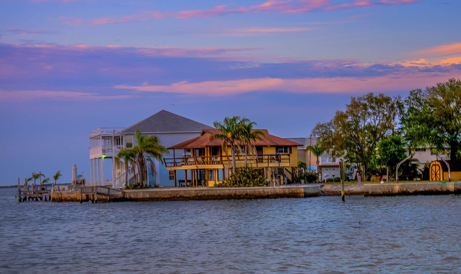 Hudson Beach: waterfront homes and buildings at sunset over calm water