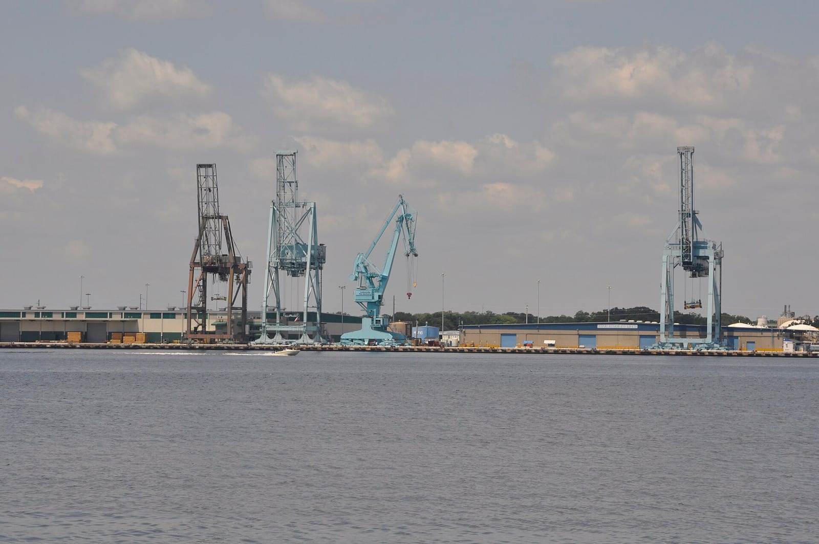 Kurzius Beach: industrial port with cargo cranes and shipping containers along waterfront