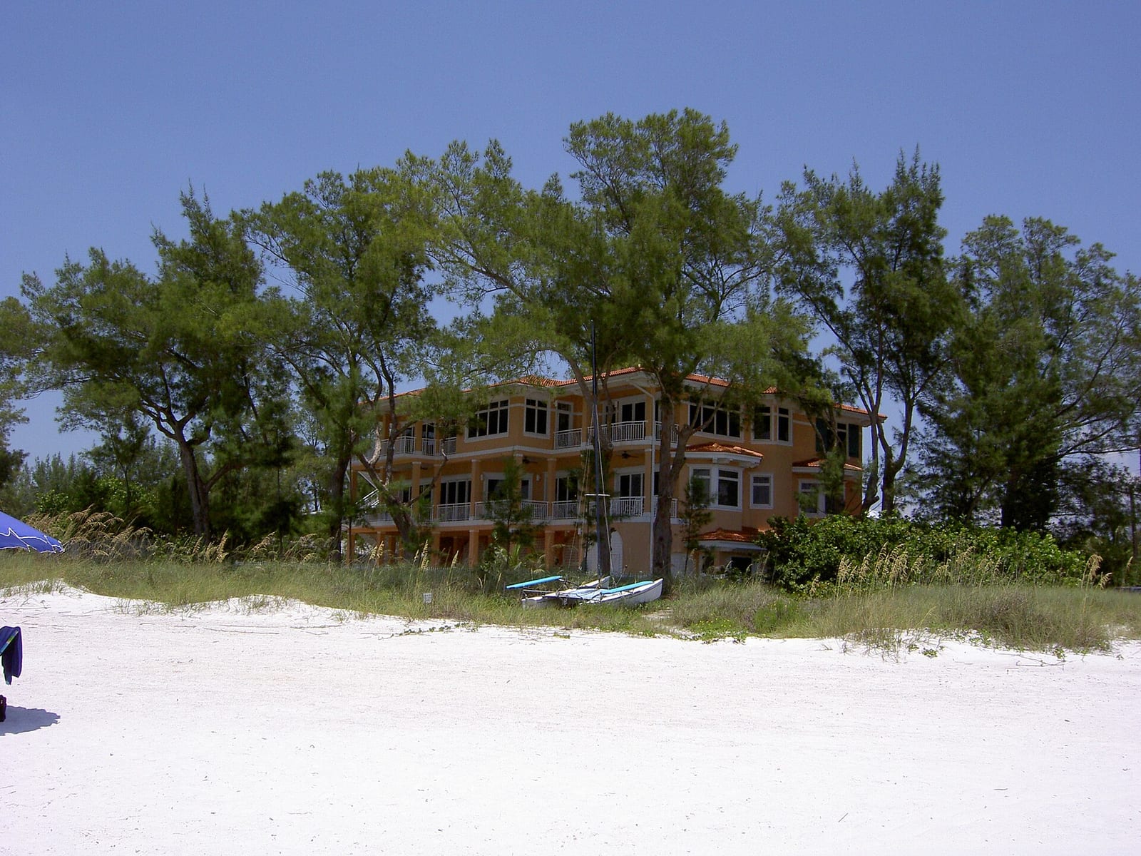 Manatee County Beach: abandoned orange building on beach with sand dunes and trees