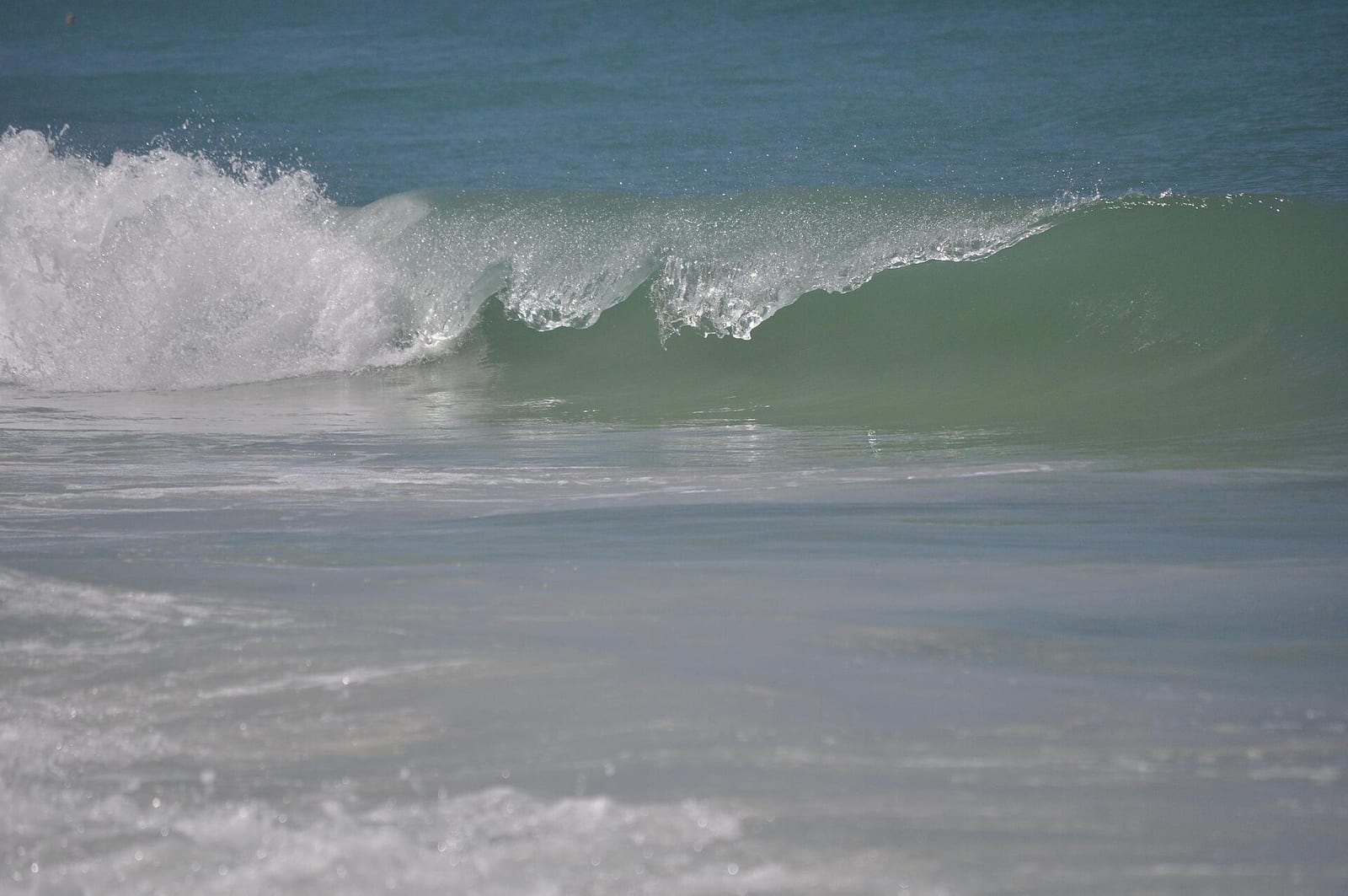 North Beach: ocean waves breaking on sandy beach with shallow water