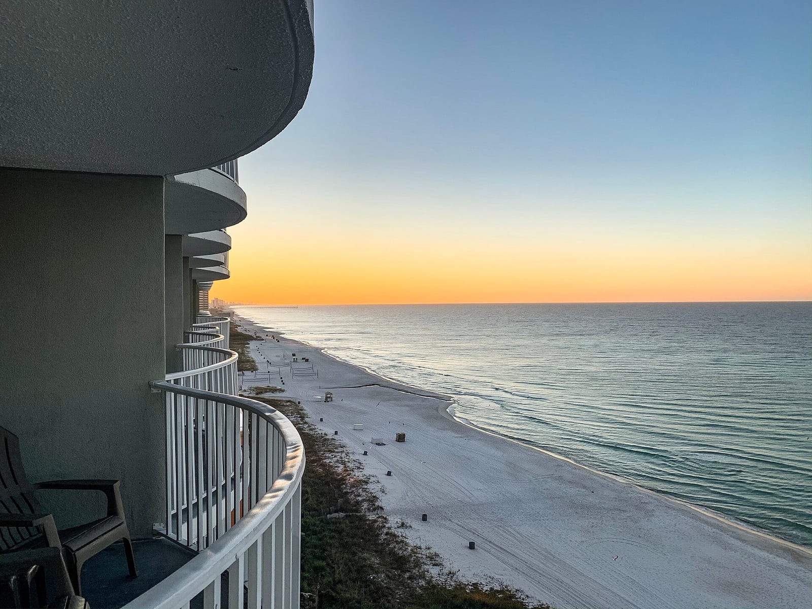 Panama City Beaches: beach view from elevated balcony at sunset with calm ocean waters