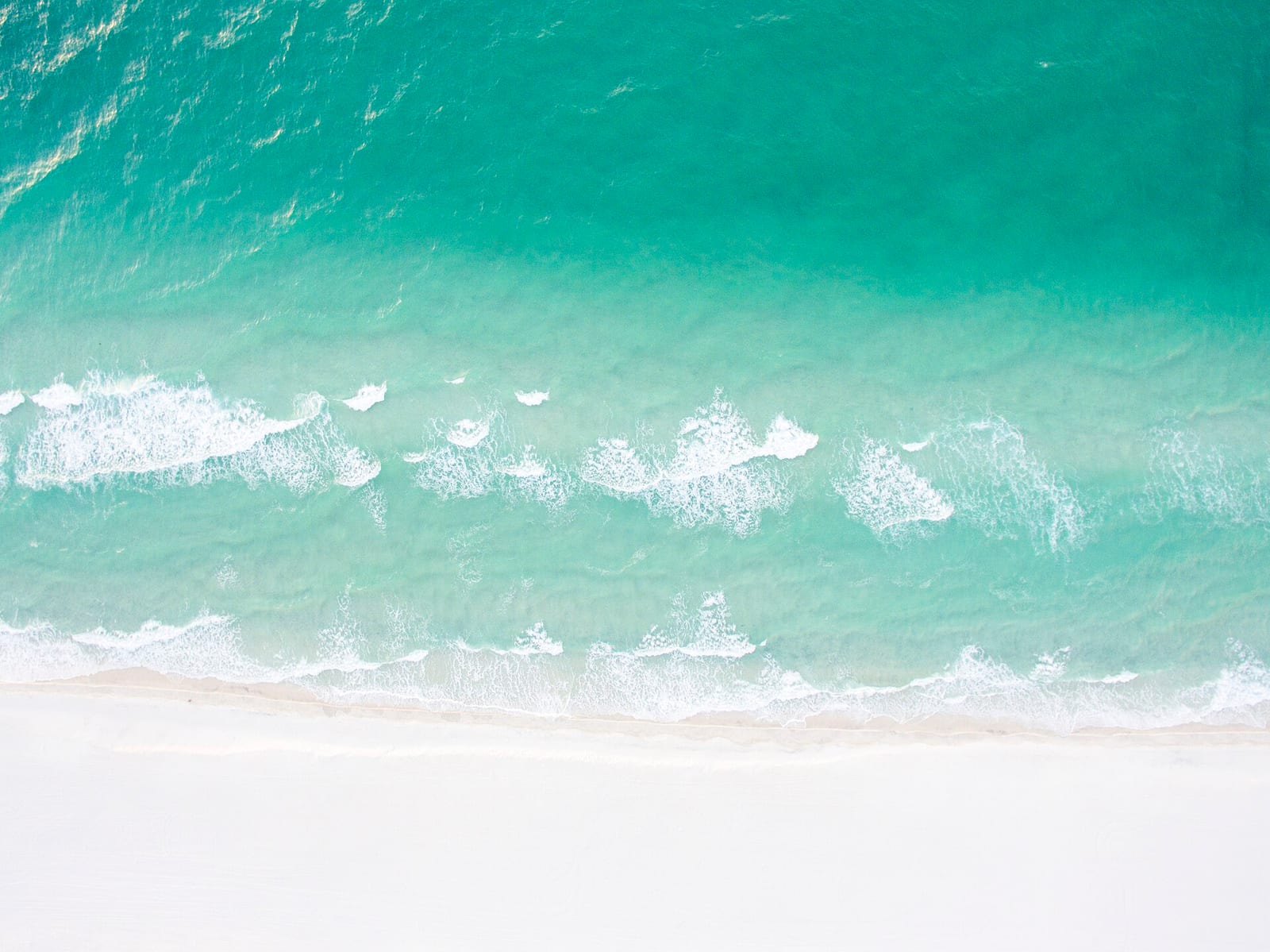 Park East On-Leash Dog Beach: aerial view of turquoise water, white sand beach, and breaking waves