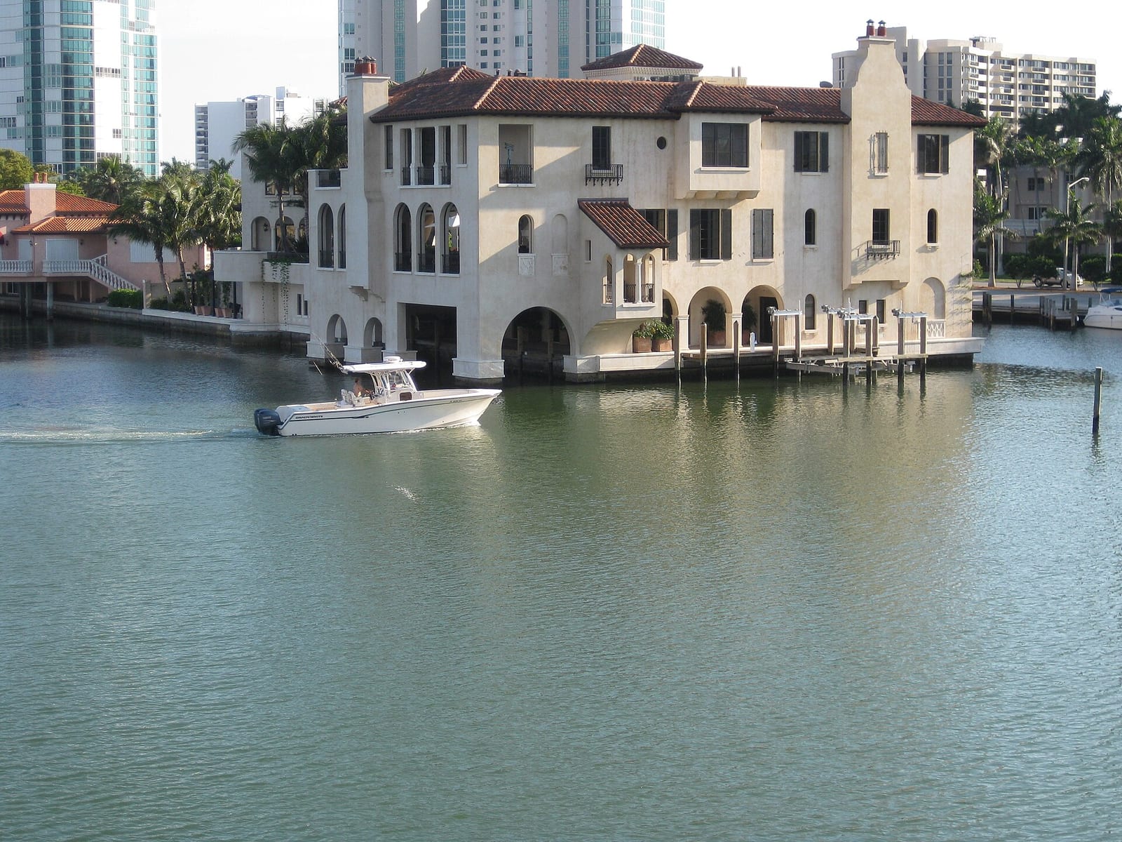 Park Shore Beach: waterfront mansion with boat moored in calm bay water