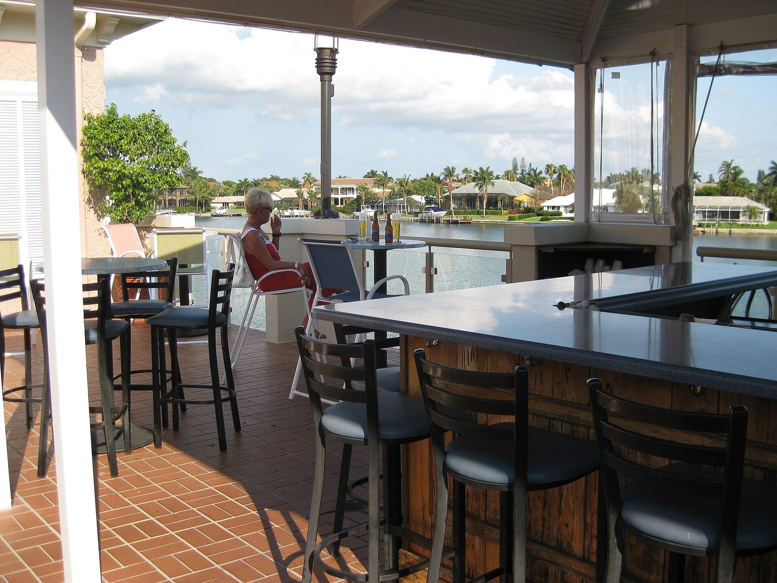 Park Shore Beach: waterfront dining area with bar seating overlooking residential canal homes