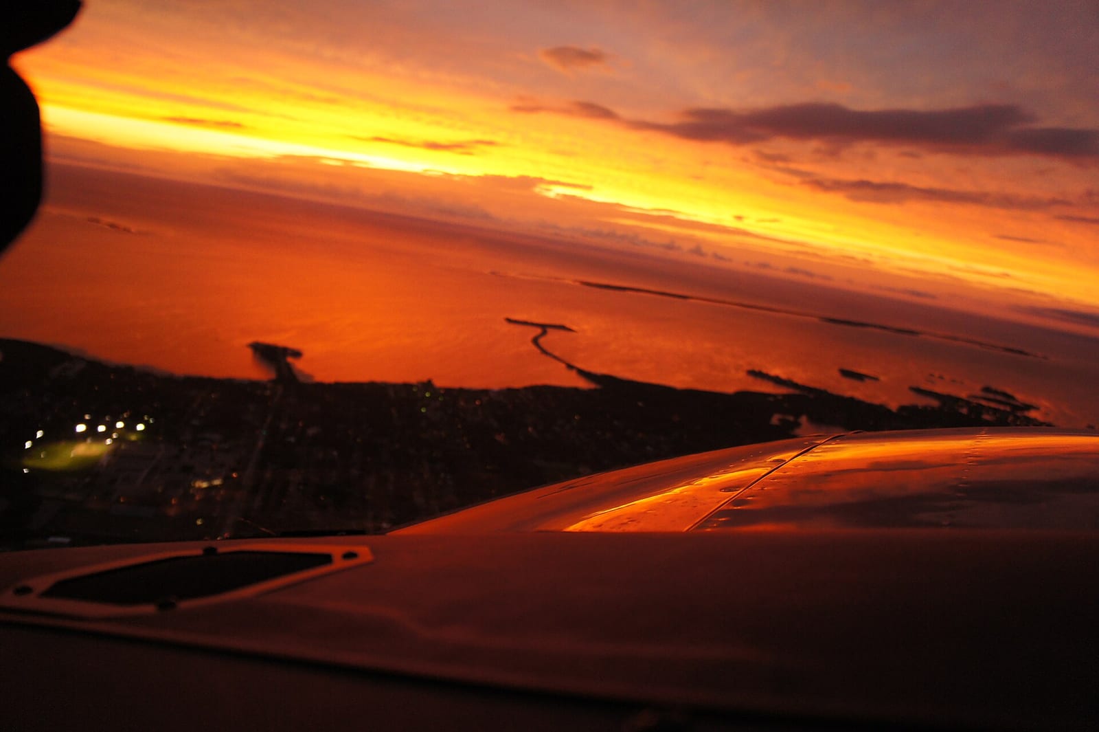 Pass-a-Grille Beach: sunset view from aircraft wing over coastal landscape