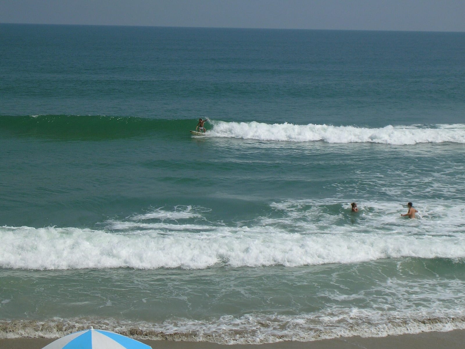Playalinda Beach (Nudist Area): beach scene with surfers, swimmers, and waves near shore
