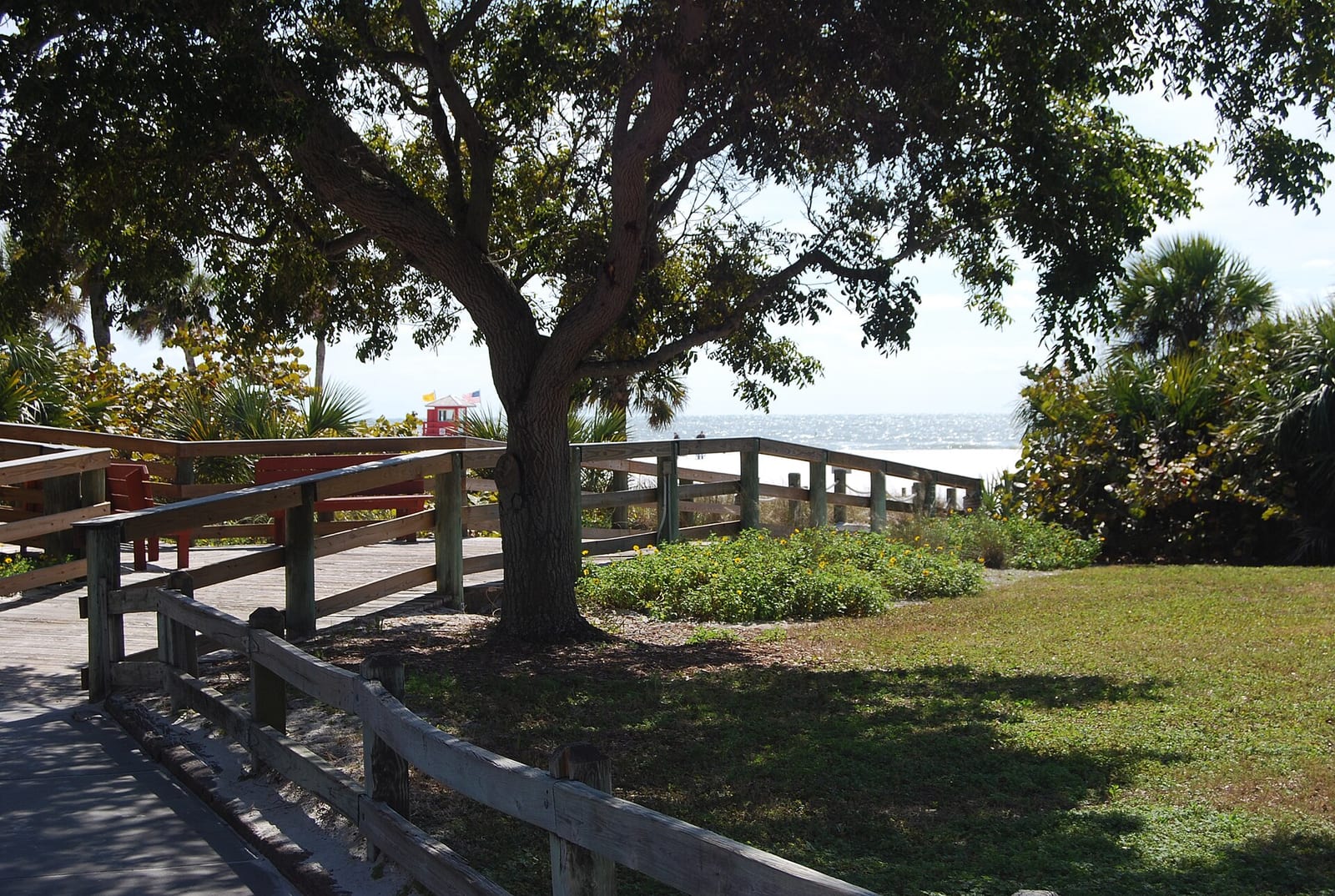 Siesta Beach: wooden boardwalk and picnic area overlooking water with trees