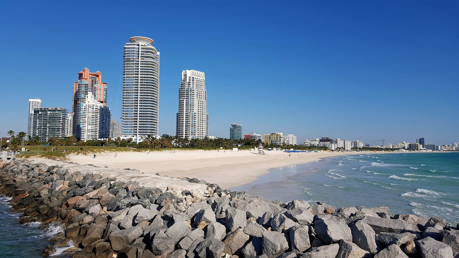 South Pointe Beach: beach with rocky breakwater, high-rise buildings, and turquoise ocean