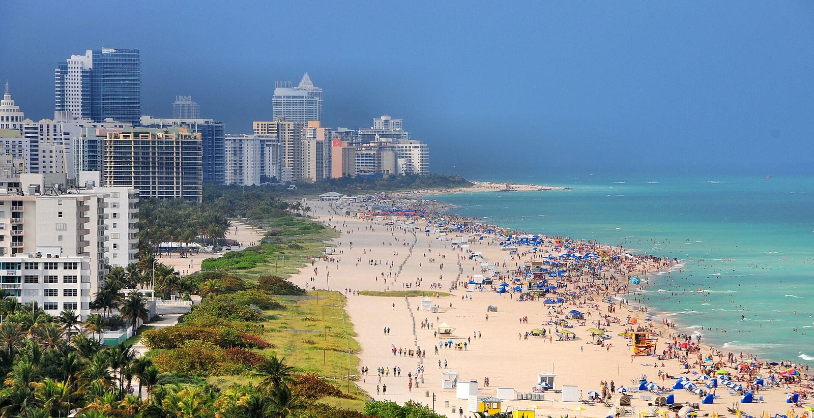 South Pointe Beach: sandy beach with swimmers, umbrellas, and high-rise buildings along shore