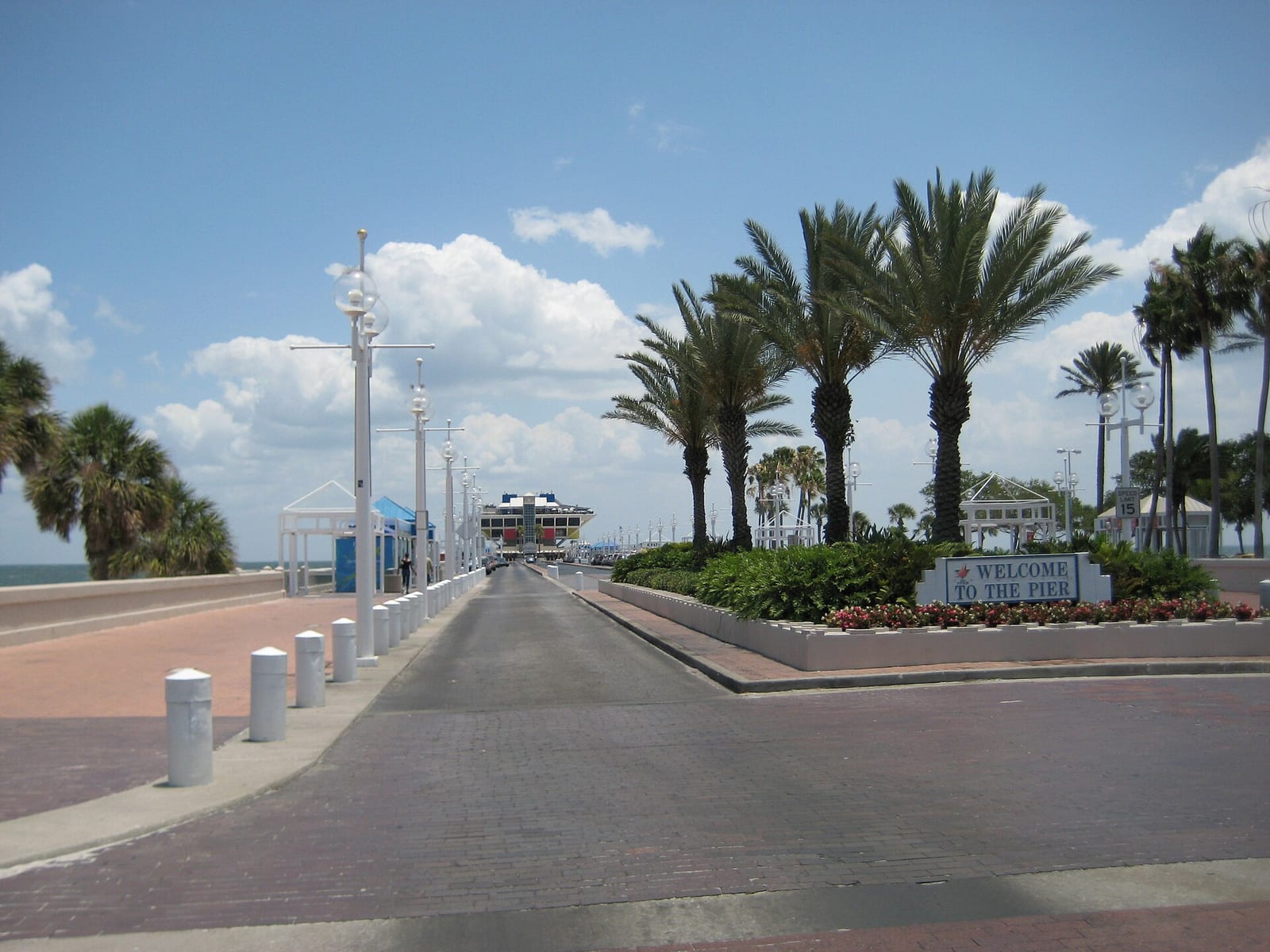 Spa Beach: pier entrance with palm trees, boardwalk, and welcome sign