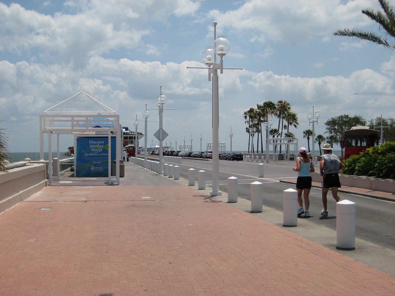 Spa Beach: boardwalk with street lamps, palm trees, runners, and parked cars
