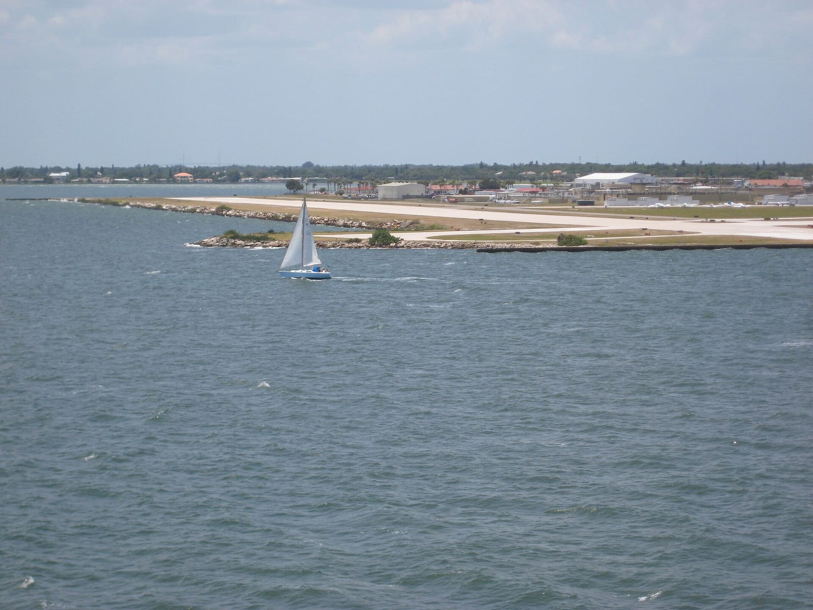 Spa Beach: sailboat in water with sandy beach and coastal town buildings