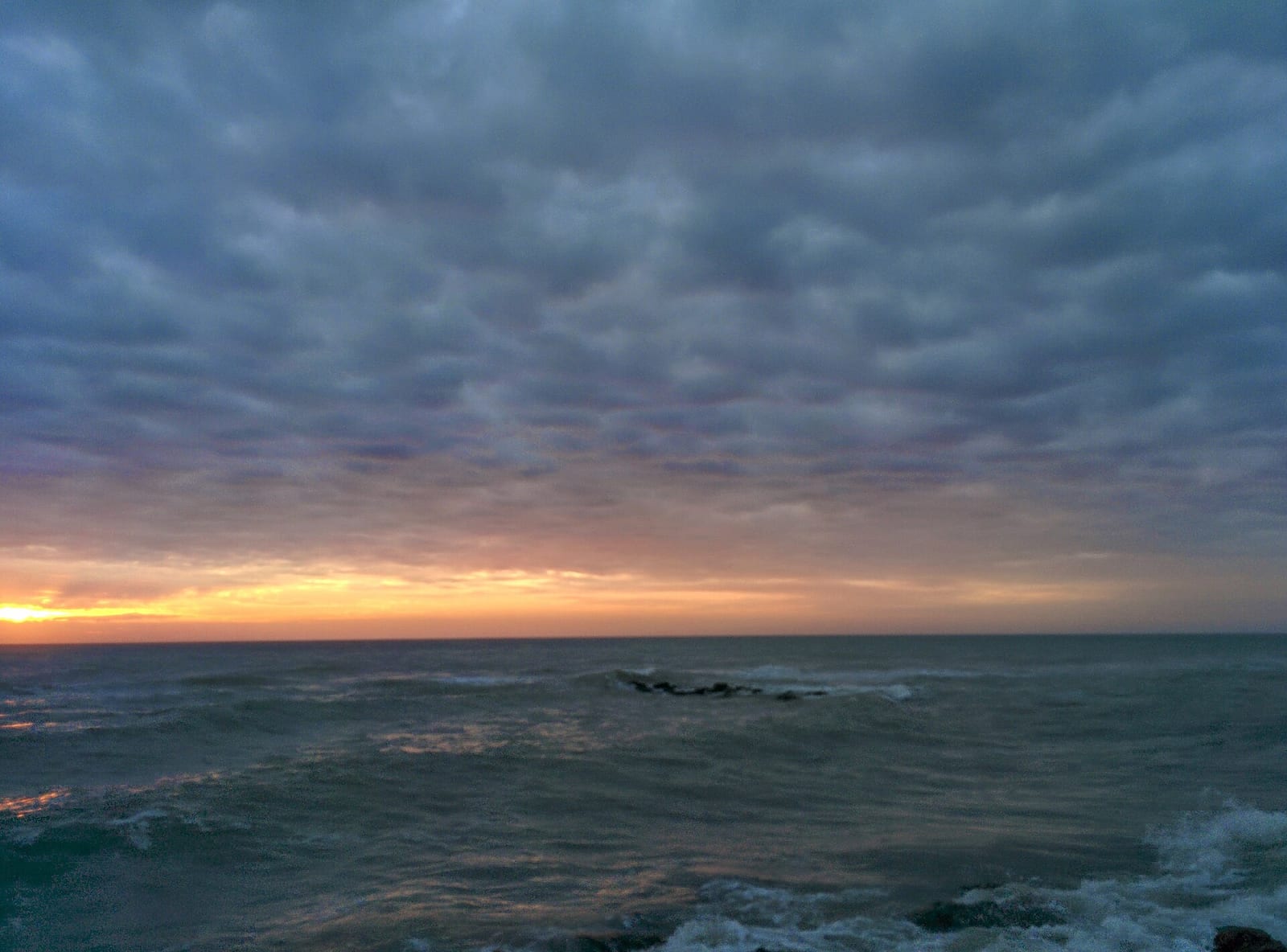 Venice Beach: sunset over ocean with clouds and waves at shoreline