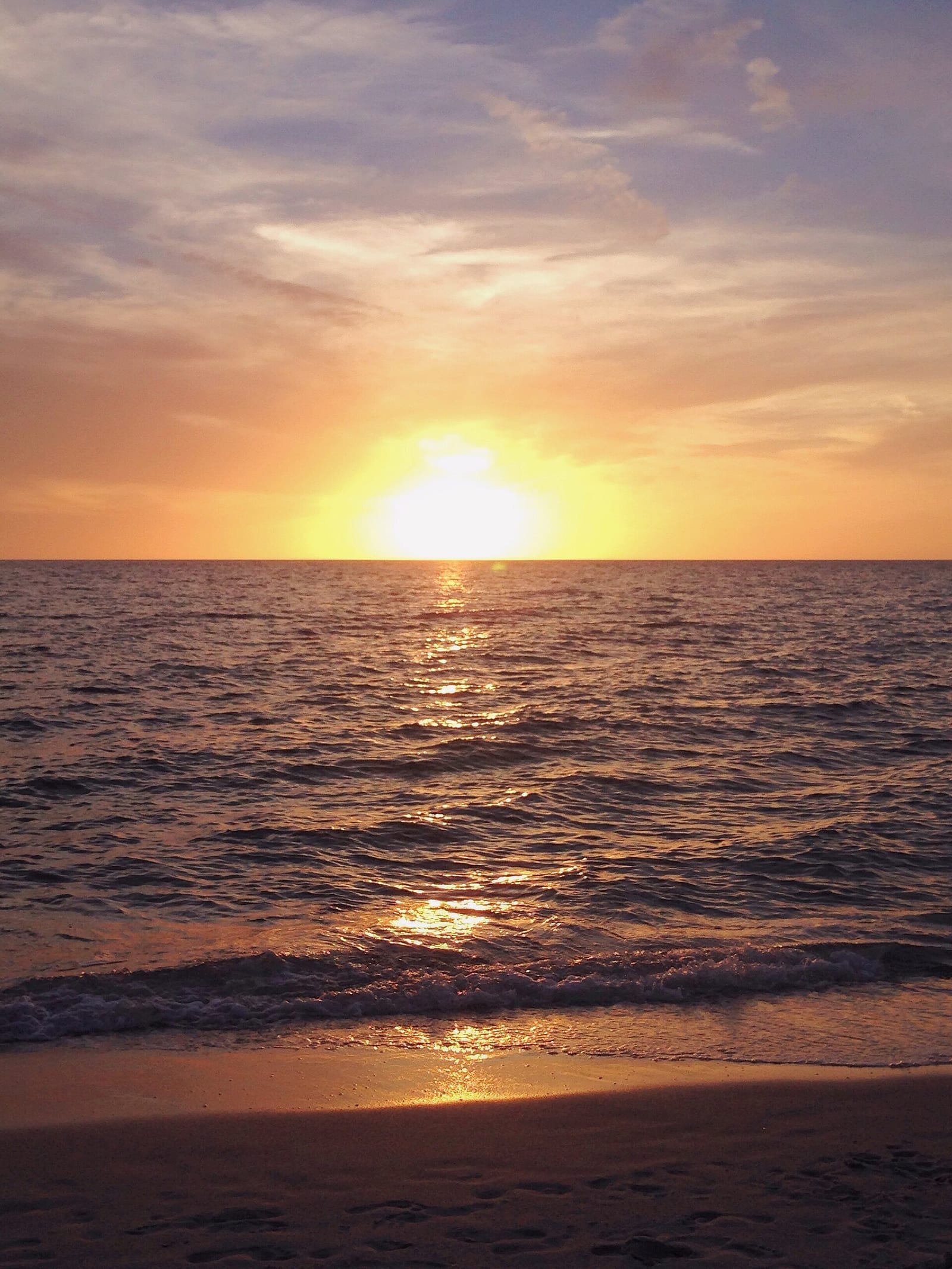 Via Miramar Beach: sunset over ocean with waves and sandy beach shore