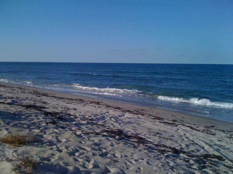 Walton Rocks Beach: sandy beach with gentle waves and clear blue sky