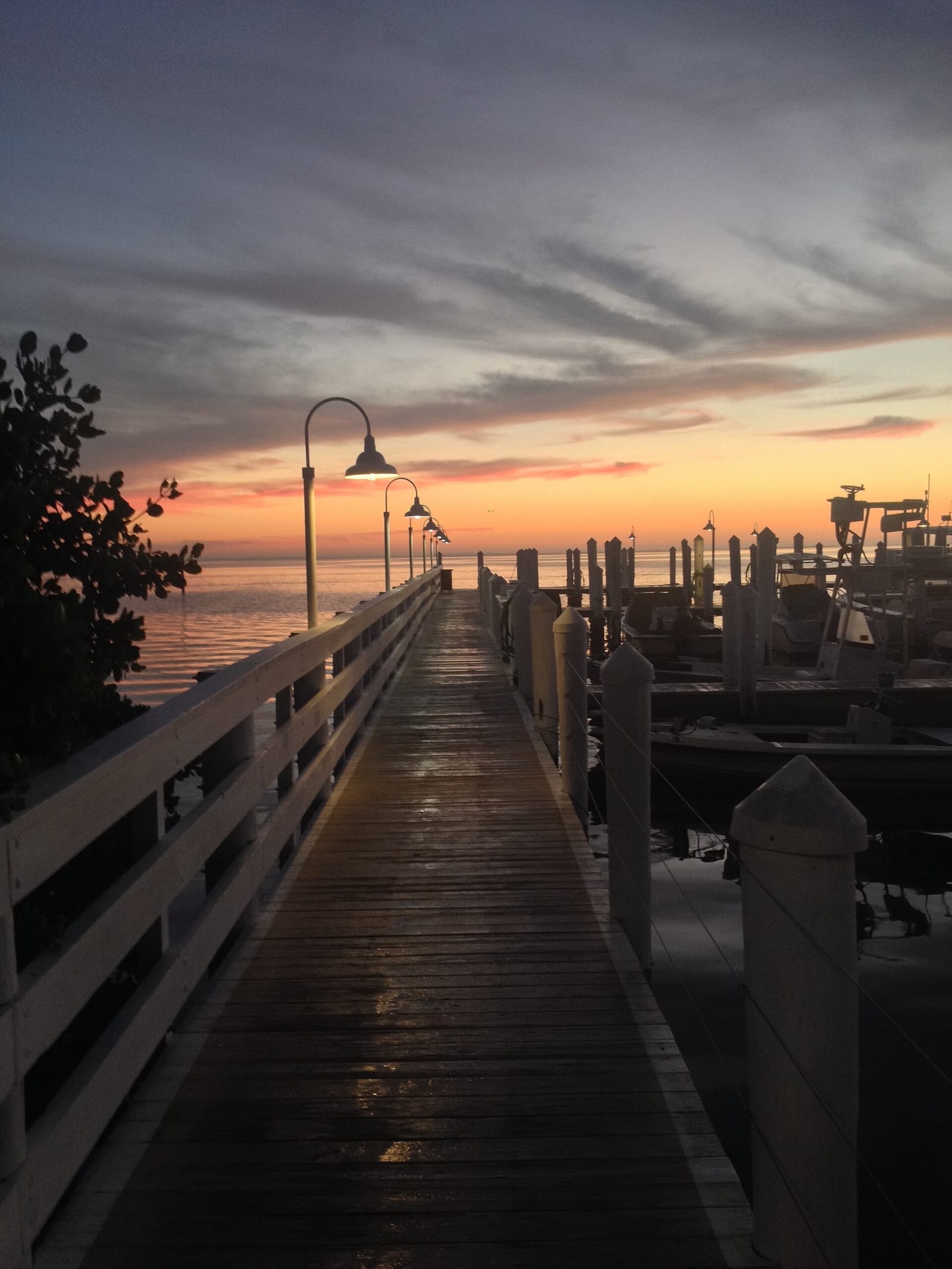 Turner's Beach: wooden pier at sunset with lamp posts and moored boats