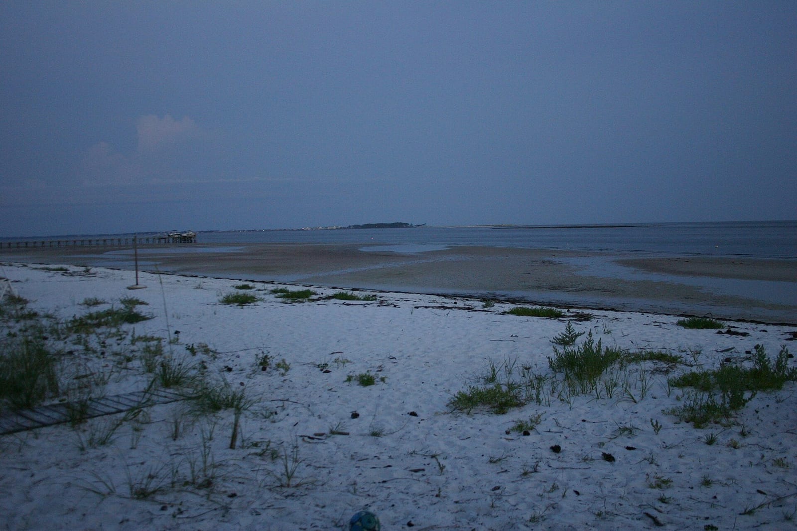 Wilson Beach: sandy beach at low tide with pier and shallow water, dusk